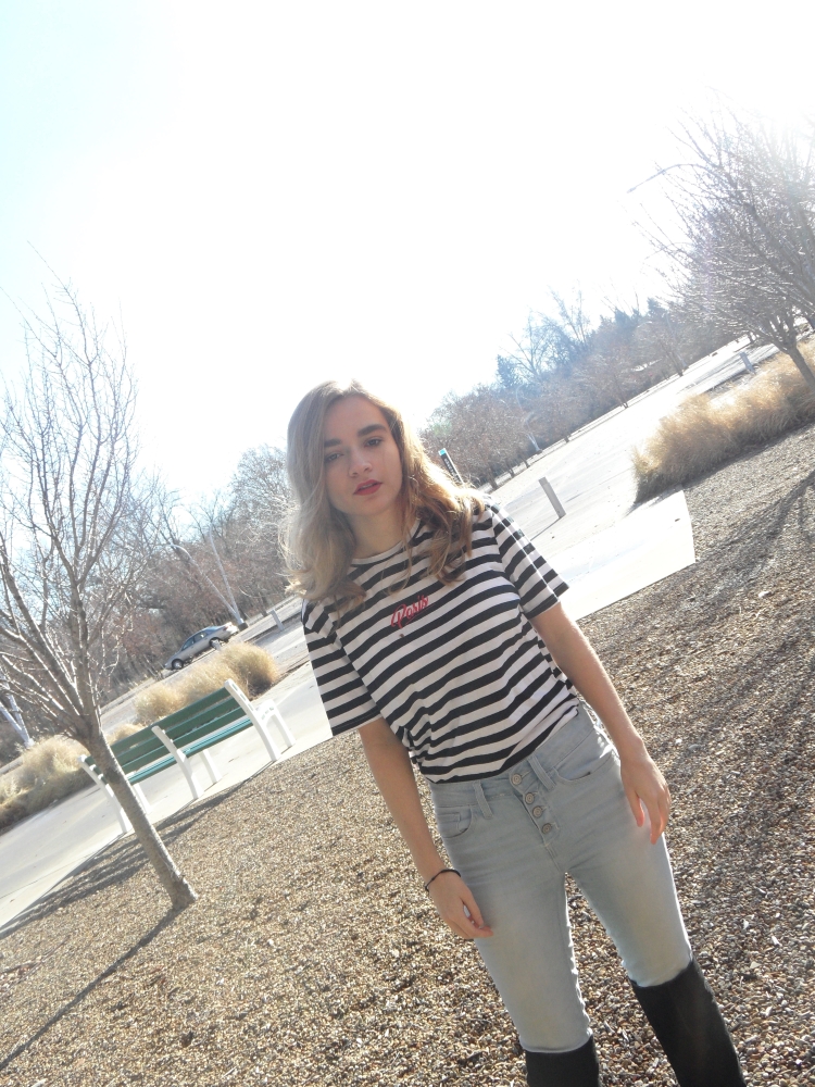 fashion blogger poses in striped top and jeans